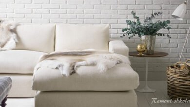 Белый диван на фоне белой кирпичной стены
